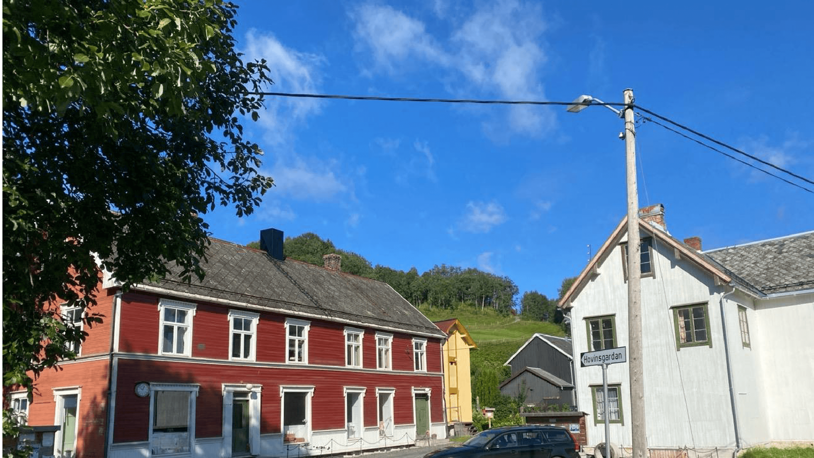 Den gamle handelsbygningen Gamle Hovin, rød tømmerbygning i to etasjer ved Hovinsgardan på Hovin