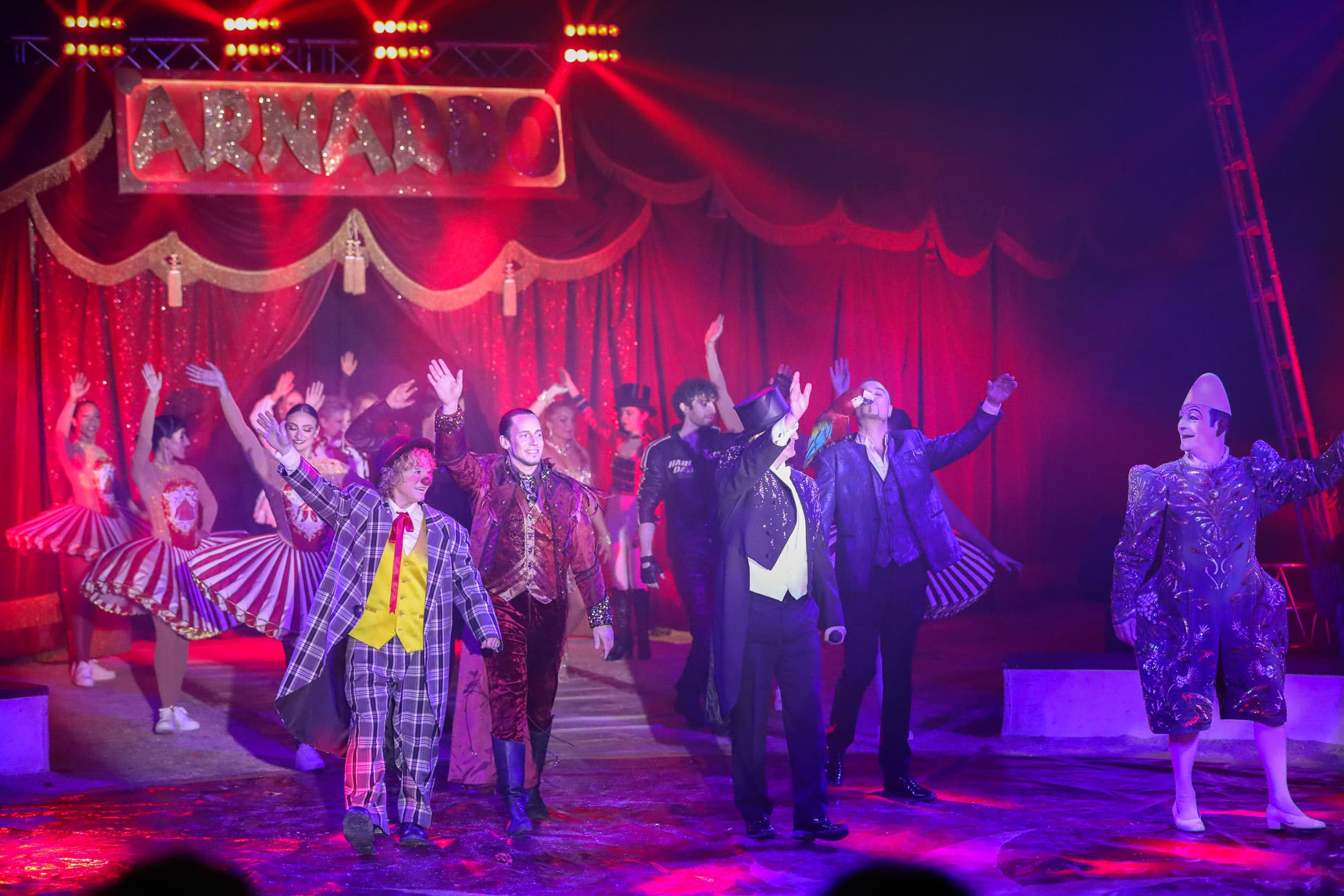 Hele ensemblet i Cirkus Arnardo på scenen under ARNARDO-skiltet