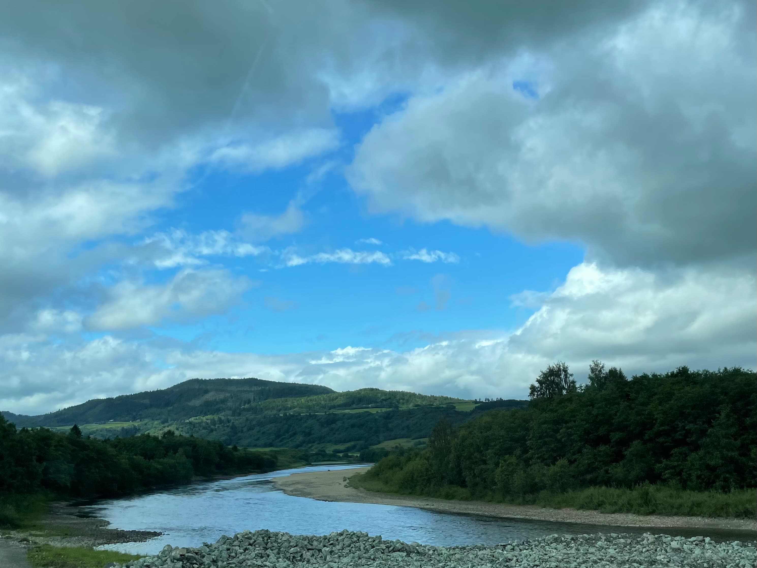 Gaulaelva som slynger seg gjennom dalbunnen i Melhus, med grusører og skogkledde åser.